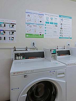A row of washing machines are lined up in a laundromat.