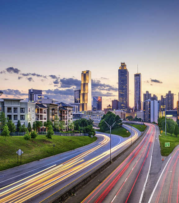 A cityscape with a highway in the foreground and buildings in the background at 445 Cleveland Apartments in Atlanta, GA, 30354