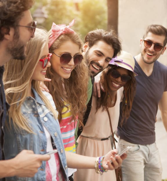 a group of young people looking at a cell phone