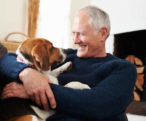 a man sitting on a couch with his dog