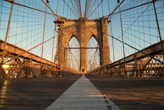 a view of the brooklyn bridge at sunset