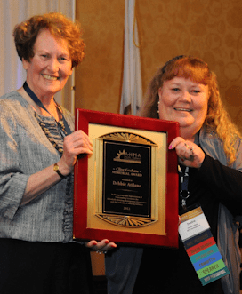 person receives award from person for her contributions to the community