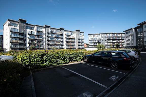 a parking lot with cars in front of an apartment building