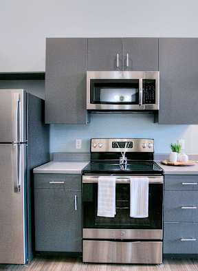 A modern kitchen with a stainless steel refrigerator and oven.