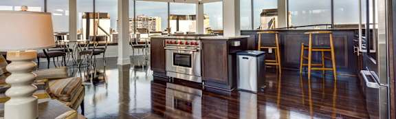 A modern kitchen with a striped sofa and a view of the city.