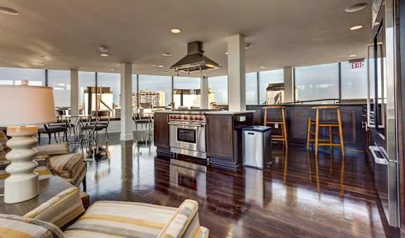 A modern kitchen with a striped sofa and a view of the city.