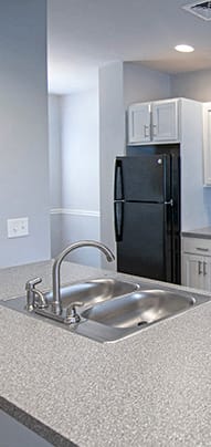 a kitchen with white cabinets and a black stove and refrigerator