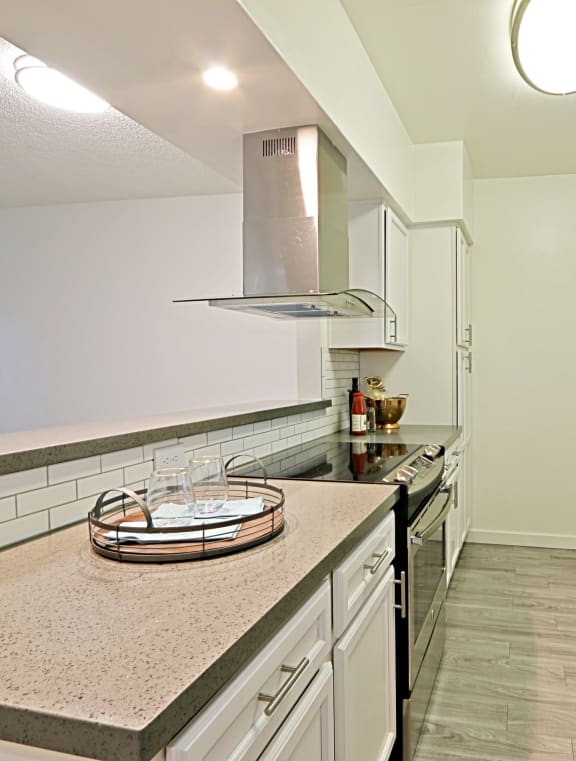 a kitchen with white cabinets and stainless steel appliances