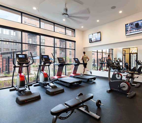Spacious Workout Room with Ellipticals, mirrored wall, and Fitness Equipment at CityWay Apartments in Indianapolis