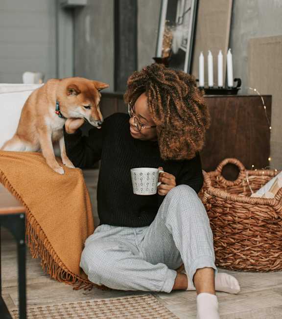 A woman with a dog sitting on the floor at 445 Cleveland Apartments in Georgia, 30354