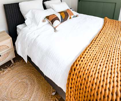 a bedroom with a bed and a painting on the wall