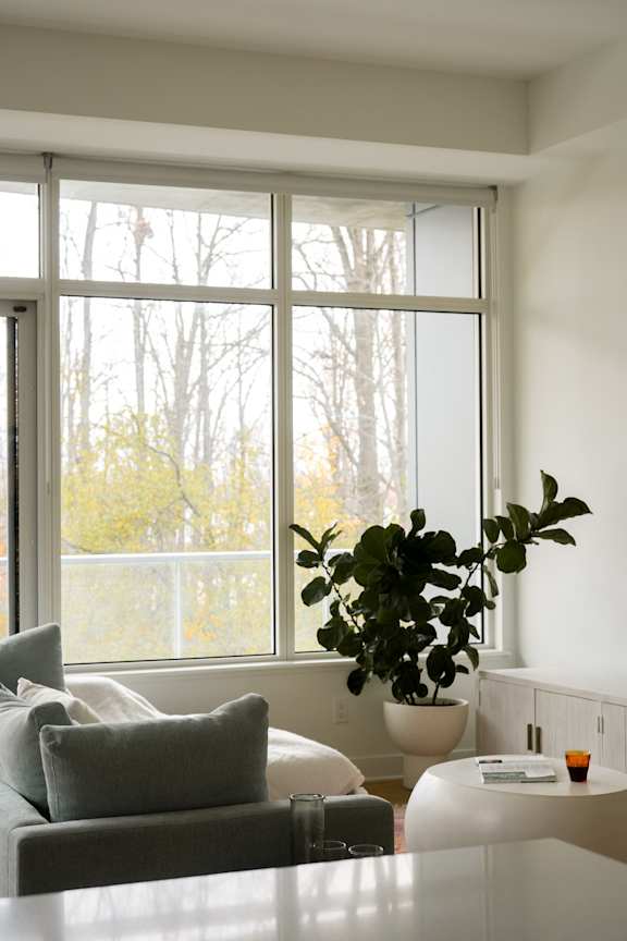 A living room with a white couch and a large window.