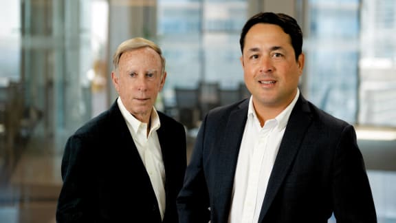 two men in suits standing next to each other