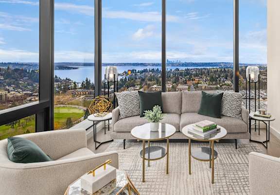 a balcony with two chairs and a table and a view of a lake and trees  at Two Lincoln Tower, Bellevue, WA, 98004 at Two Lincoln Tower Apartments, Bellevue, WA, 98004