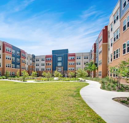 A large grassy area in front of a row of buildings.