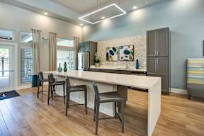 A modern kitchen with a long island and chairs.