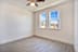 A room with a ceiling fan and two windows.