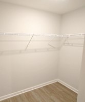 Empty white closet with shelves and a door.