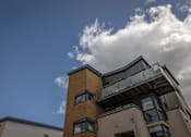 Thumbnail 6 of 7 - the top of a building with a blue sky and clouds