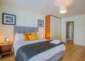 Thumbnail 1 of 4 - a bedroom with a bed and a closet