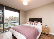 Thumbnail 1 of 3 - a bedroom with a large window and a bed