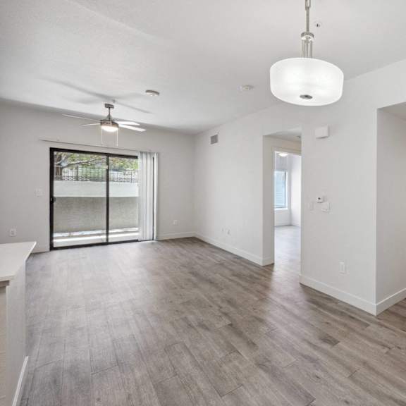 A spacious room with a ceiling fan and sliding glass doors.