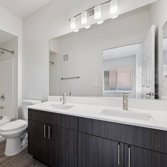 A white bathroom with a tub, toilet and sink.
