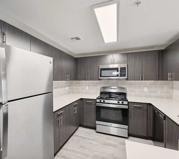 A modern kitchen with a black refrigerator and stainless steel appliances.