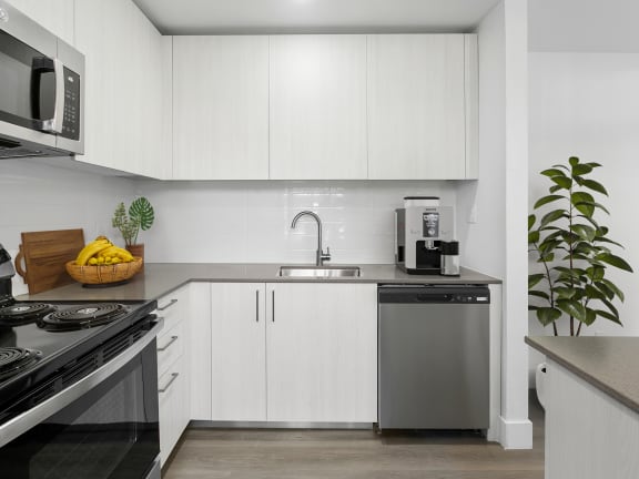 a kitchen with white cabinets and stainless steel appliances and a sink