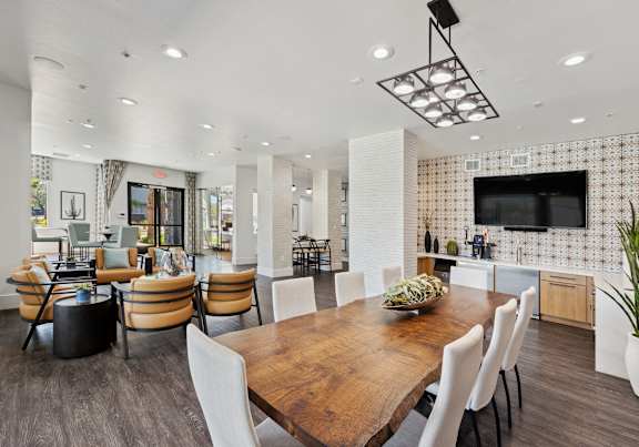 A modern dining room with a wooden table and chairs.