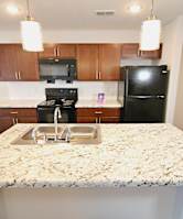 an empty kitchen with black appliances and white cabinets