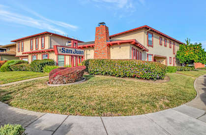 the front view of the building with a lawn and a sidewalk