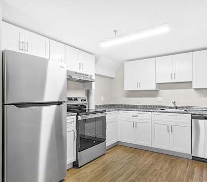 an empty kitchen with stainless steel appliances and white cabinets at Clocktower and Velvet Mill Apartments, Connecticut, 06040