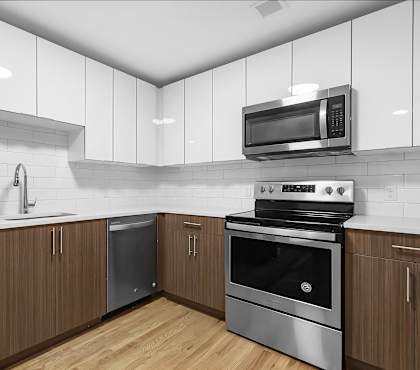 a kitchen with white cabinets and stainless steel appliances at 1188 Lofts in Bridgeport, CT, 06604