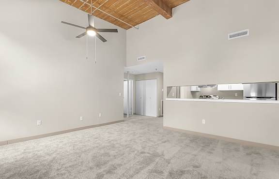 an empty living room with a ceiling fan and a kitchen at Clocktower and Velvet Mill Apartments, Connecticut, 06040