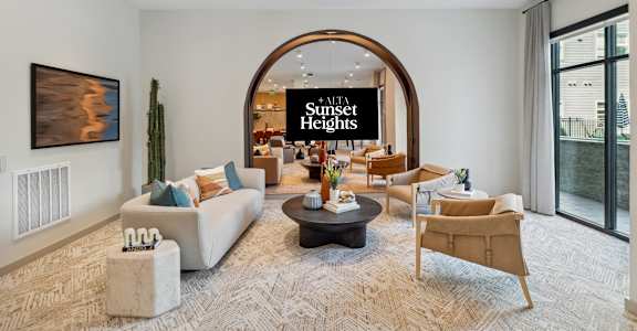 a living room with couches and chairs and an arched doorway