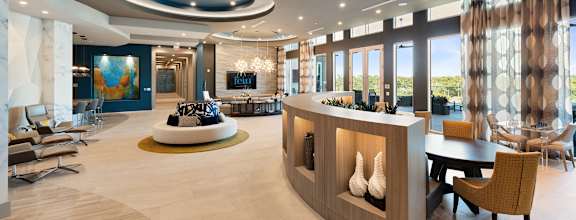 the lobby of a hotel with a reception desk and a large window