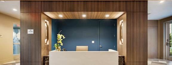 a large lobby with a reception desk and a blue wall