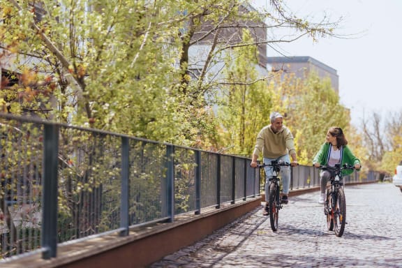 a man and a woman riding bikes on a bridge