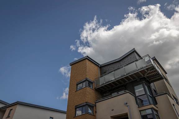 the top of a building with a blue sky and clouds