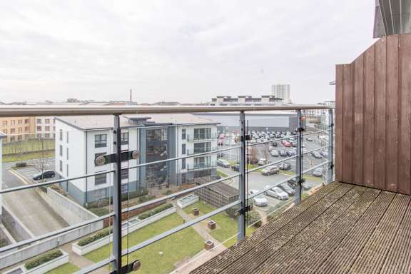 a view of a city from a balcony with a balcony railing