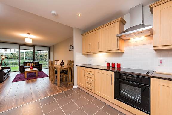 a kitchen with wooden cabinets and a stove and a table with chairs