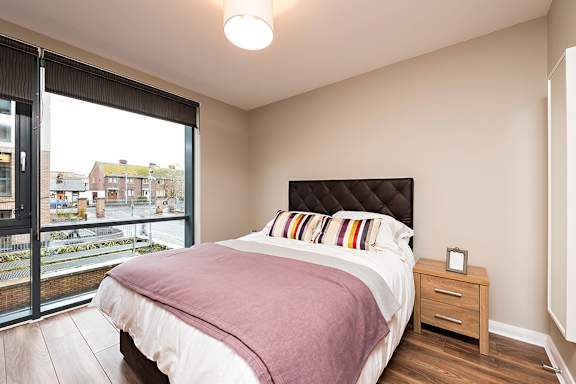 a bedroom with a large window and a bed