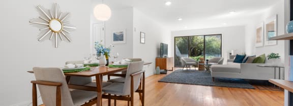 a living room and dining room with a table and chairs