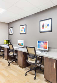 a computer lab with four computers and four chairs
