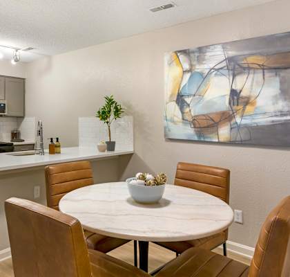 A modern kitchen with a dining table and chairs.