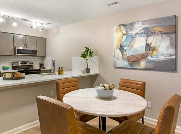 A modern kitchen with a dining table and chairs.