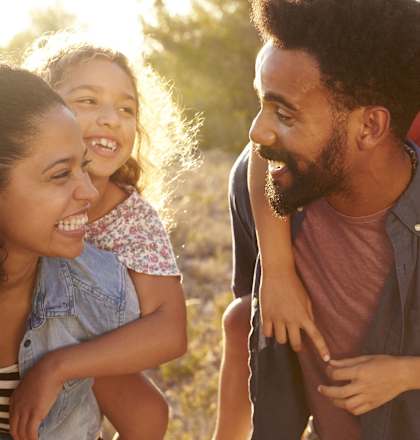 A family of three is enjoying a sunny day outdoors.