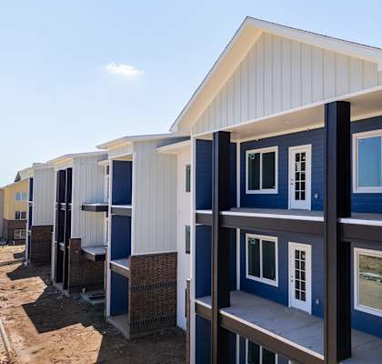 A series of white and blue prefabricated houses are lined up in a row.