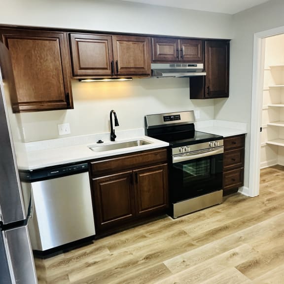 a kitchen with wooden cabinets and stainless steel appliances